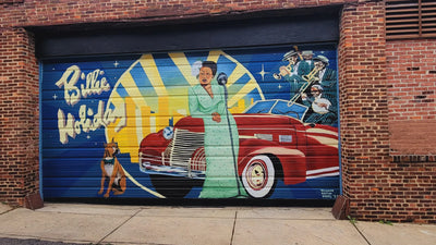 Mural of a Billie Holiday, car, and dog on a garage door with 'Billie Holiday' text.