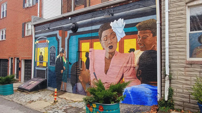 Mural on a garage door featuring Billie Holiday in a colorful setting.