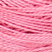 A close-up of mid tone pink yarn or thread wound tightly, filling the entire frame.
